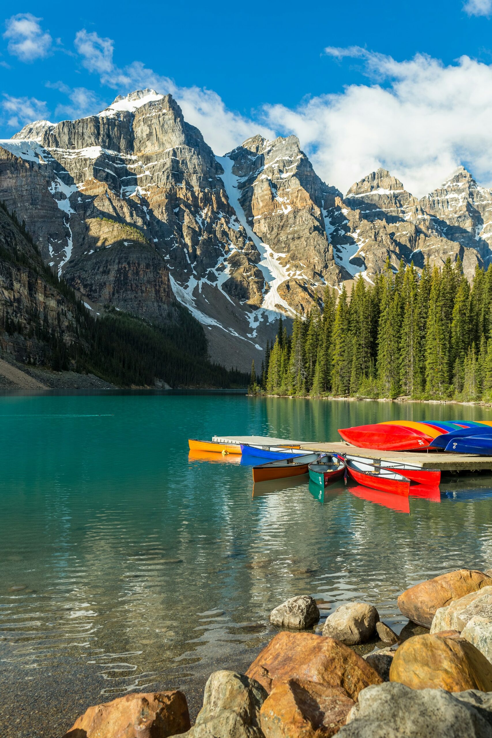 Colorful canoes lined along Moraine Lake during summer in Banff National Park